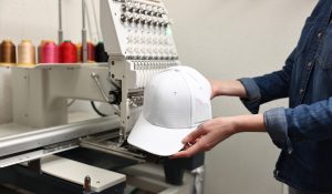 Woman with blank baseball cap for print indoors, closeup