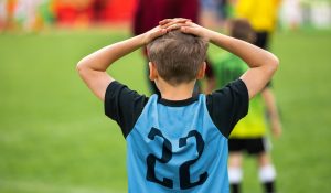 Disappointed Soccer Boy on Football Game. Kid Putting Hands on His Head After Loosing Goal